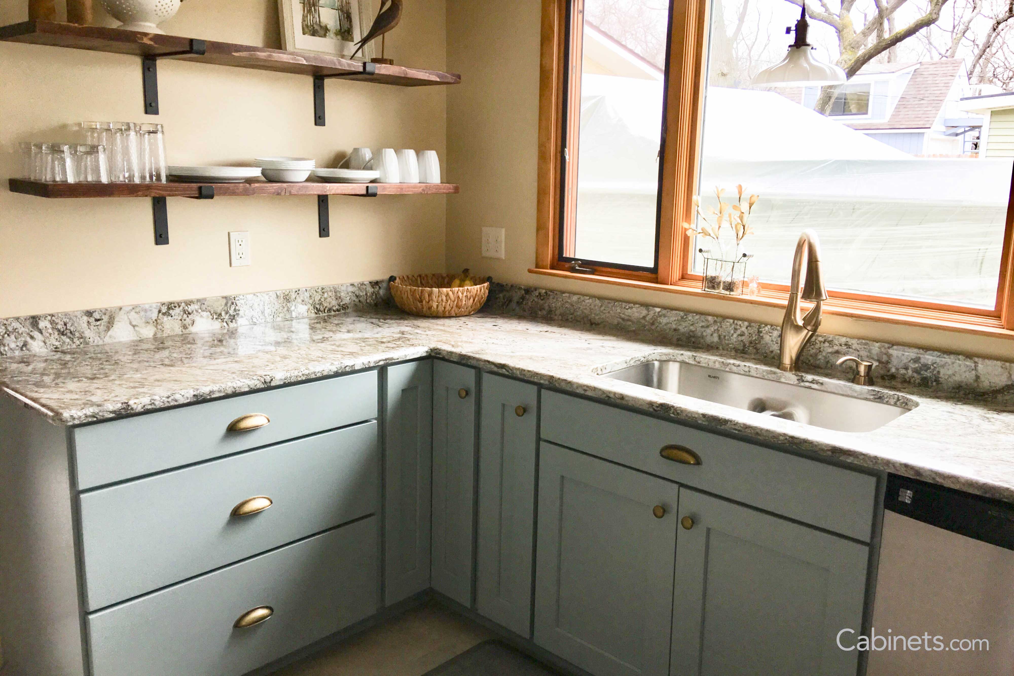 Complimentary wall color and floating shelves above Shaker Maple Haze cabintes