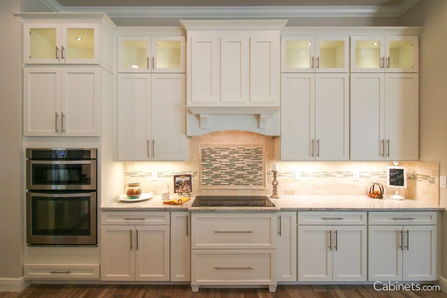 Gold pendant light over island and gold light over sink in a grey kitchen with gold hardware