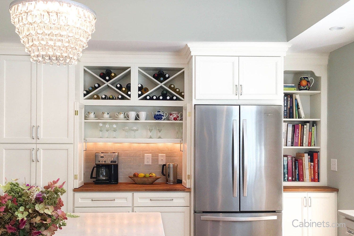 Bright white cabinets with cofee/wine nook and a crystal chandelier