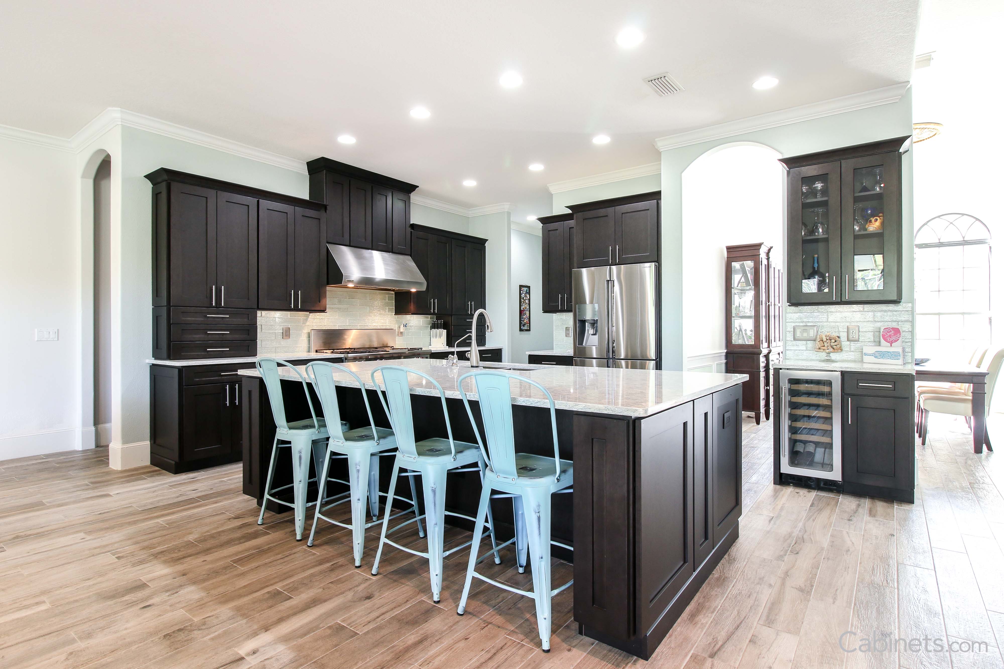 Espresso cabinets with light countertops featuring a large clean island