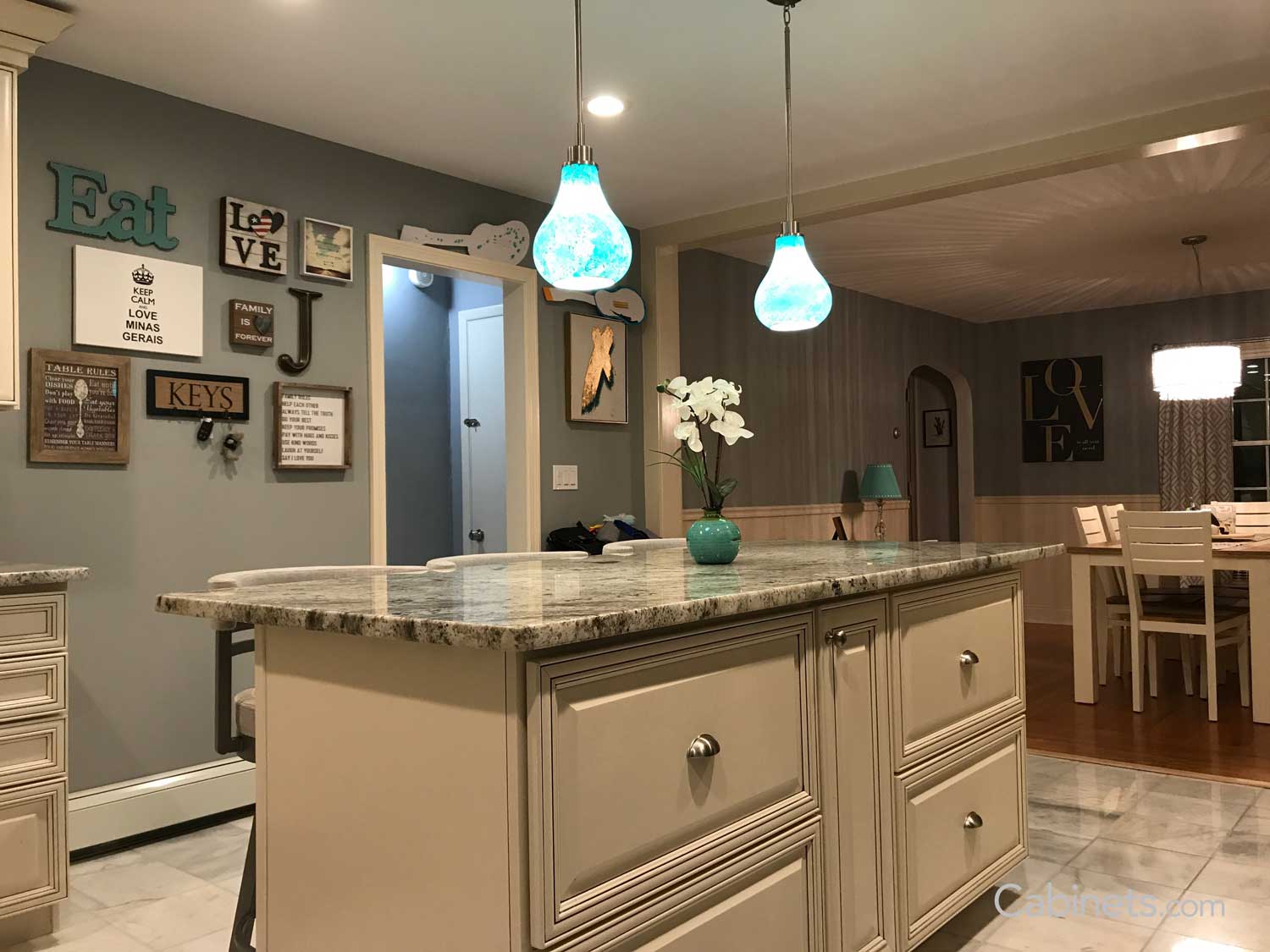 Teal pendant lights over neutral color island