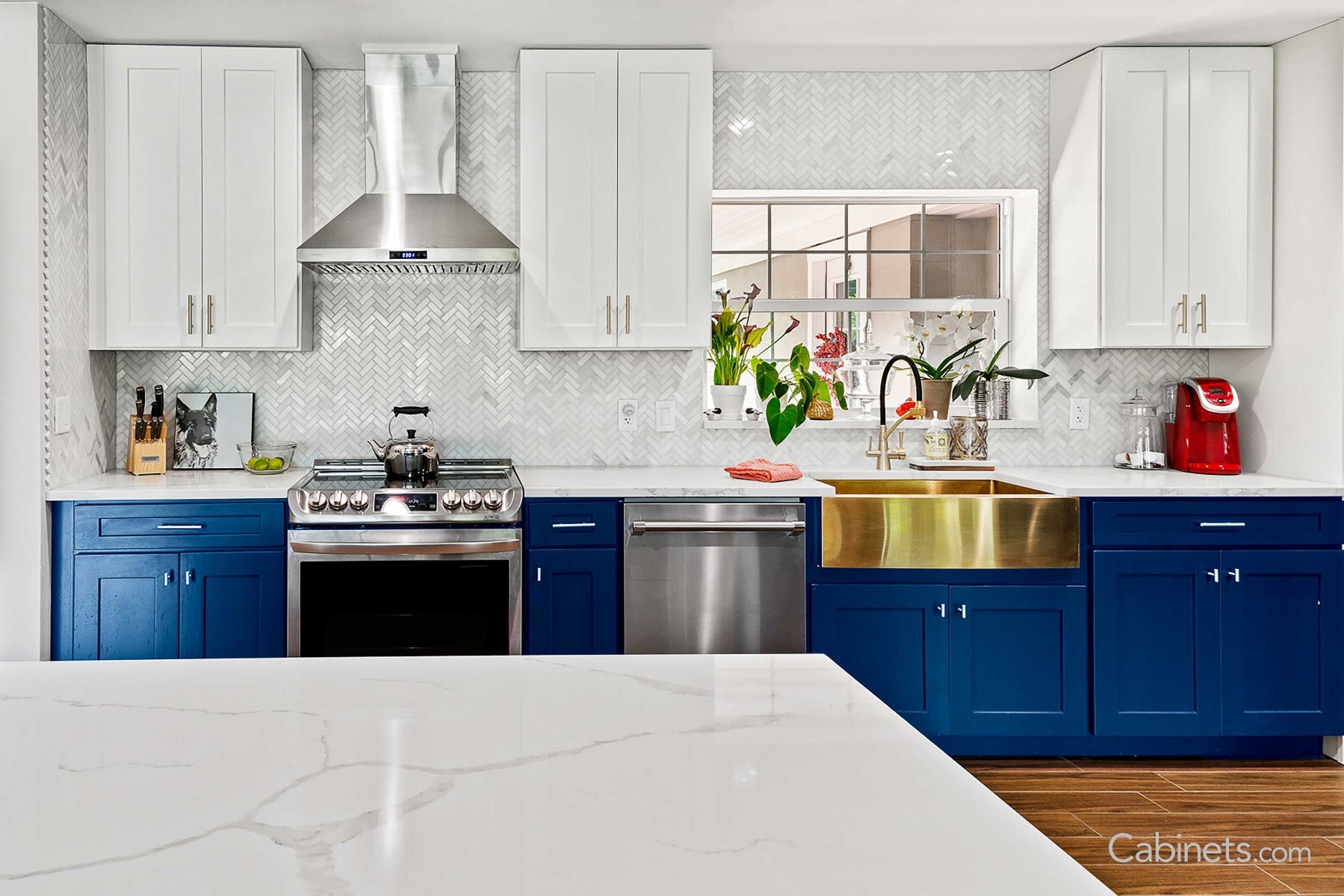 Bright white and naval cabinets with gold farmhouse sink