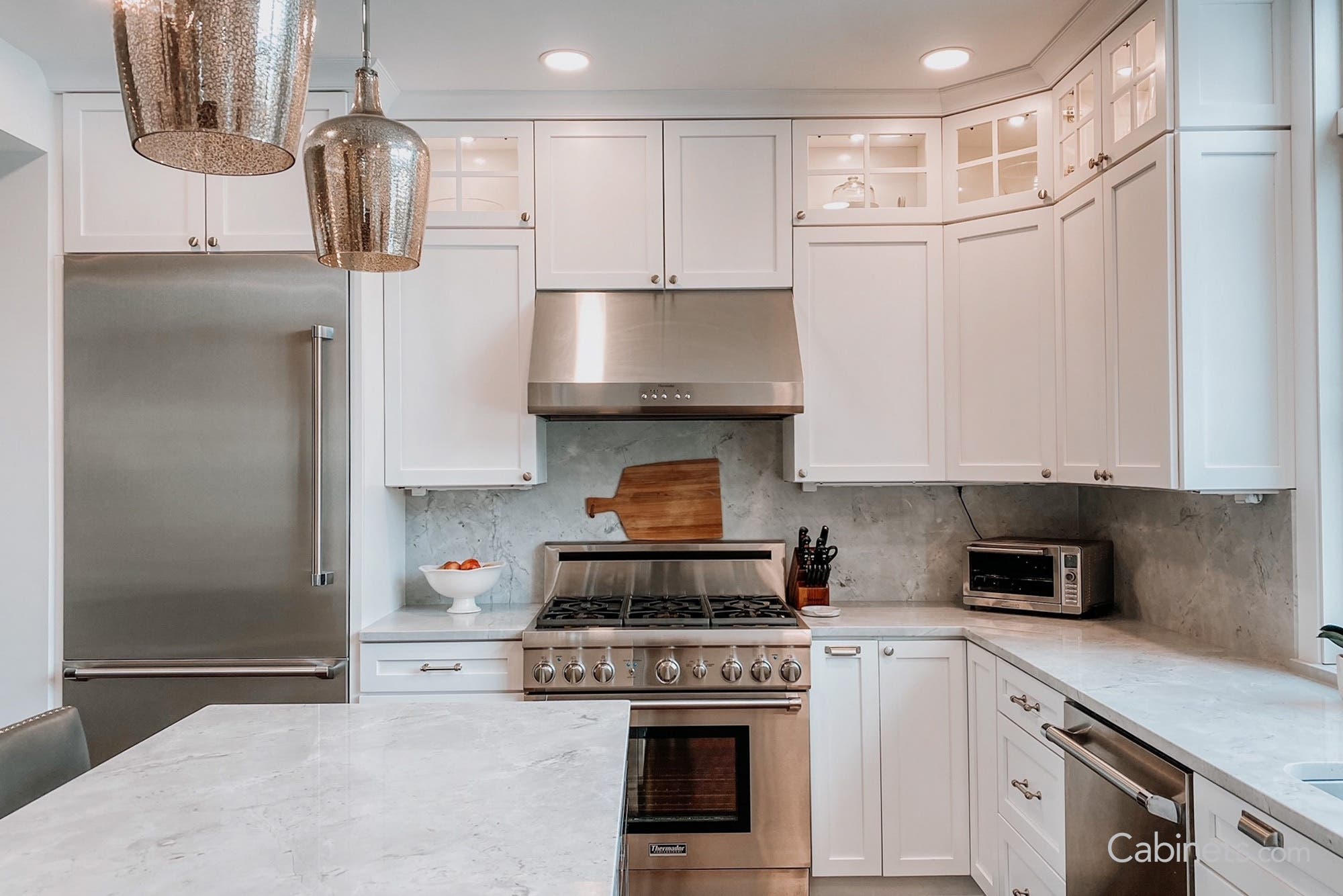 Traditional white shaker kitchen with mullion glass stacked upper cabinets.