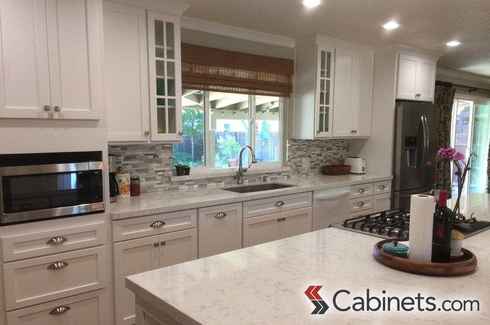 An example of well-placed glass front cabinets flanking the sink area for maximum visibility.