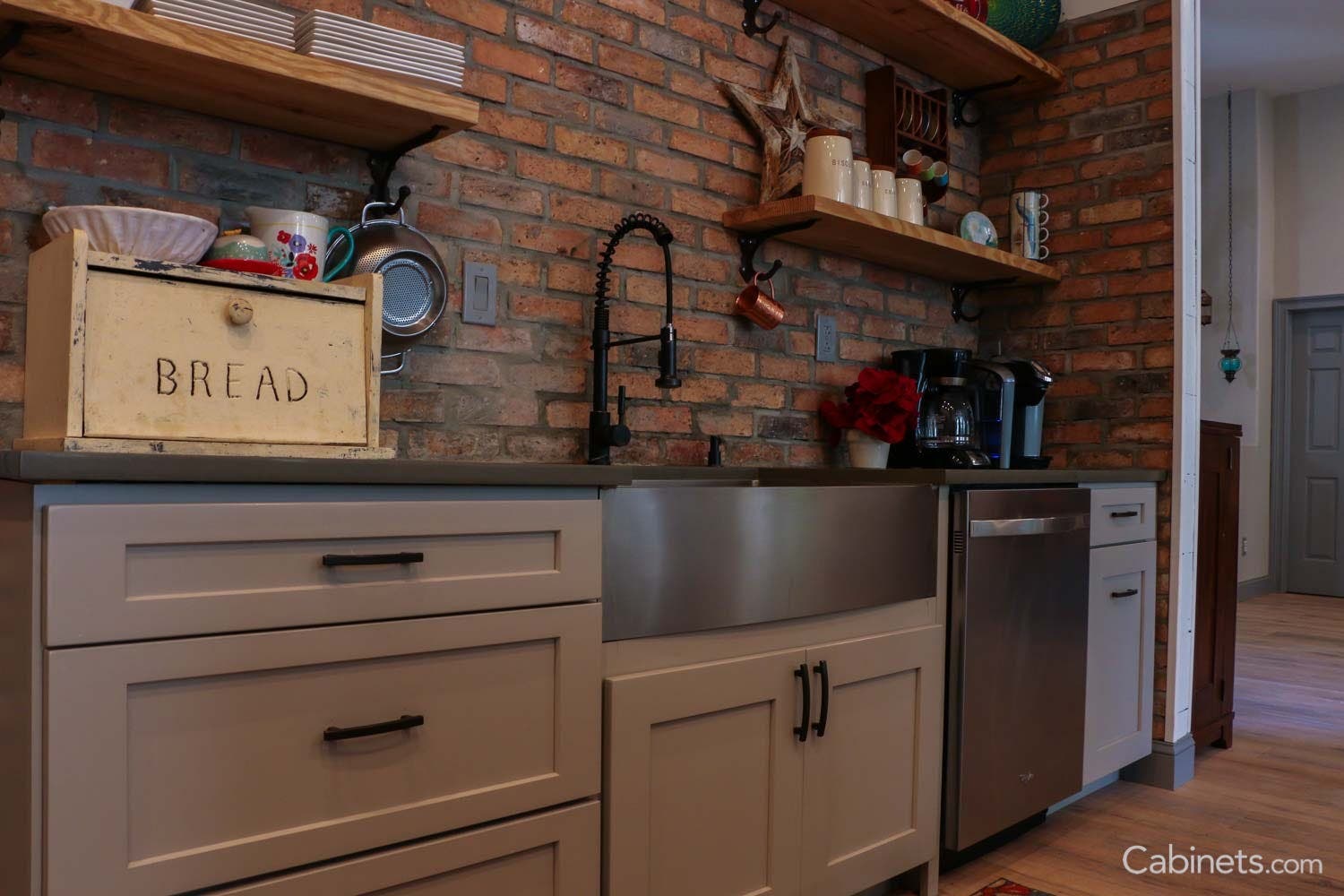 Brick backsplash and silver farmhouse style sink 