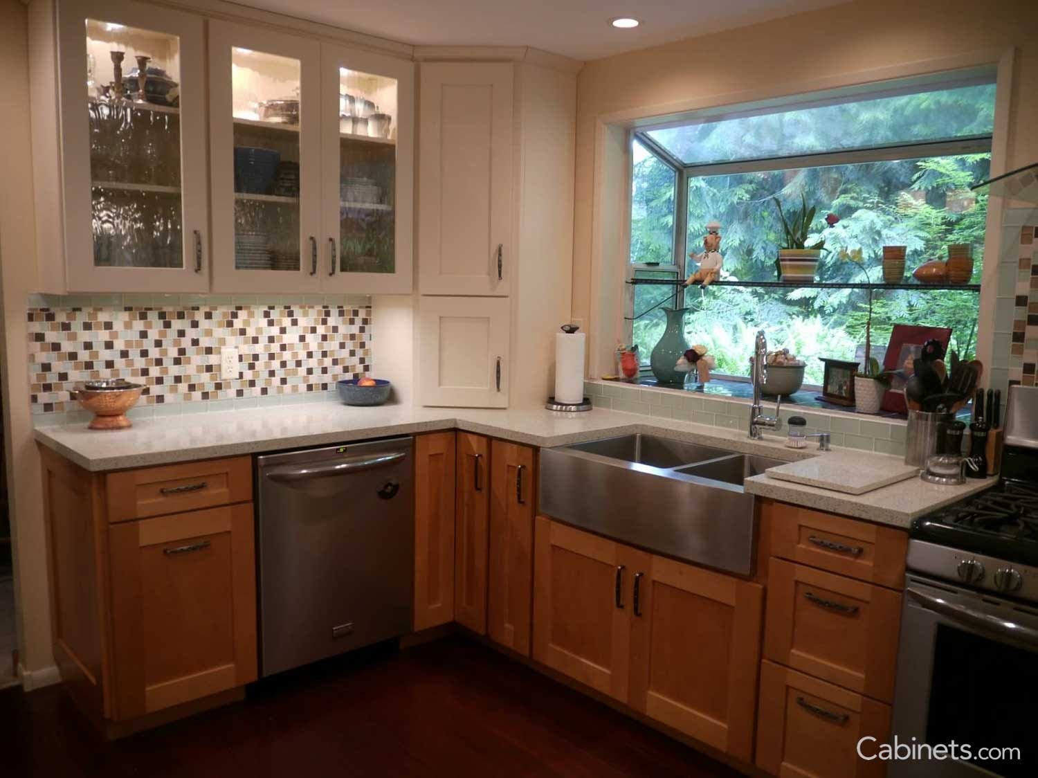 Our customer used the backsplash as an opportunity to bring in color and pattern to their kitchen. The aqua, white, and brown glass tile mosaic helps tie together the white upper cabinets with the stained lower cabinets.