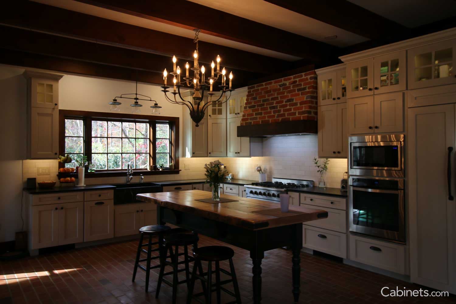 Brick Floors, Brick hood, Island with a wood countertop, Antique white cabinets